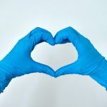 hands in blue gloves making a heart shape