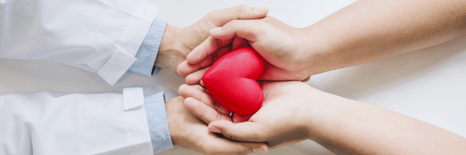 2 pair hands holding a red heart shape